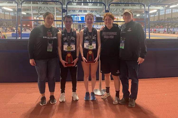 Track and field members pose with All-American awards at indoor track
