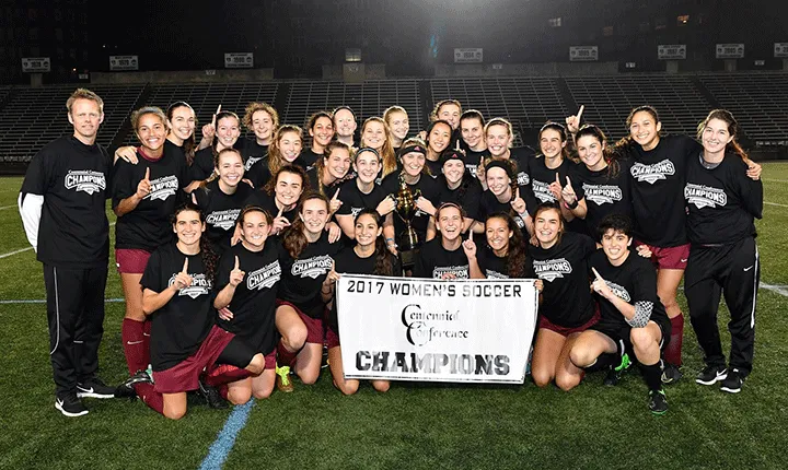 The women's soccer team poses fora photo with the Centennial Conference Championship banner