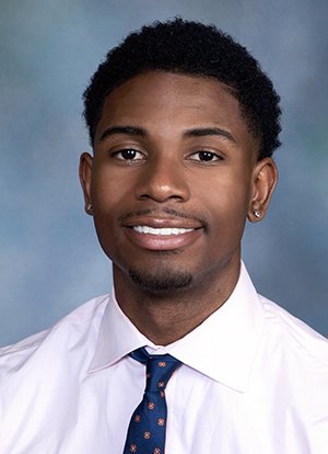 Young man in tie smiling against blue background