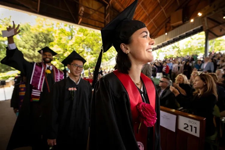 Graduates walk across stage at commencement