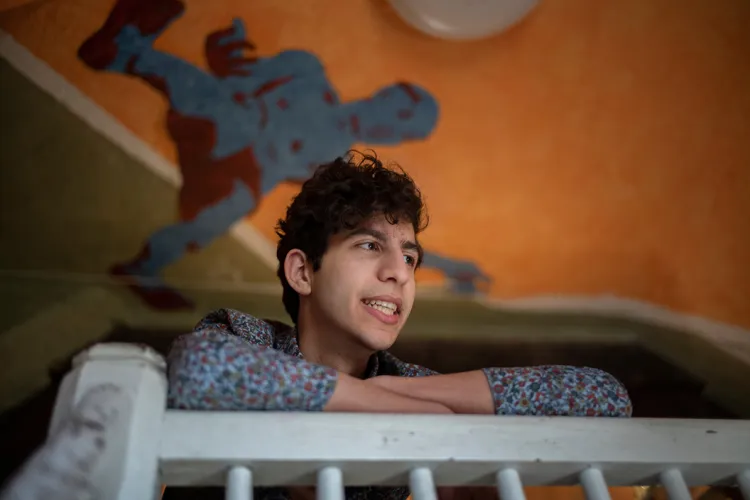 Fouad Dakwar '22 looks below and stands on balcony with arms over railing.
