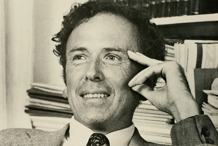 Theodore Friend, seated at desk and smiling