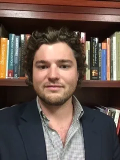 Kyle Mahoney in office in front of bookcase