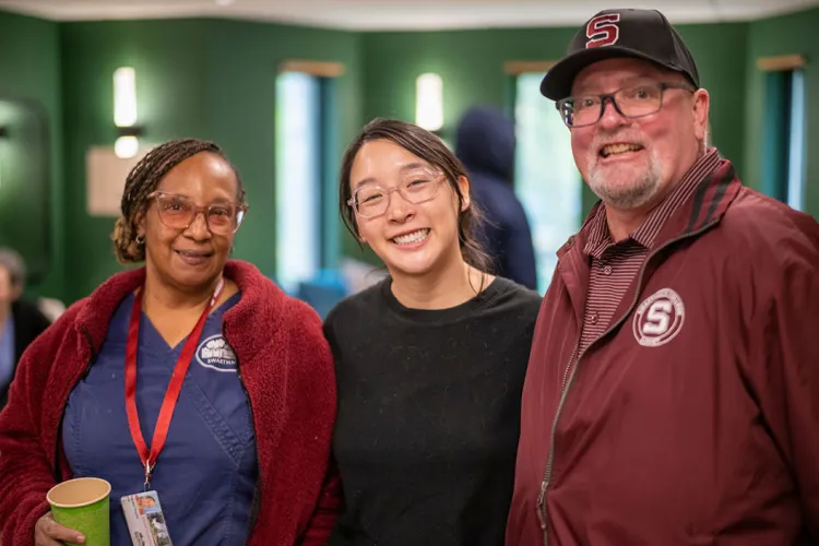 Three people pose in group photo at learning for life reception