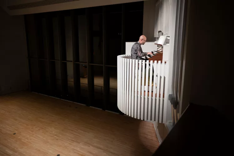 Person plays organ on elevated platform