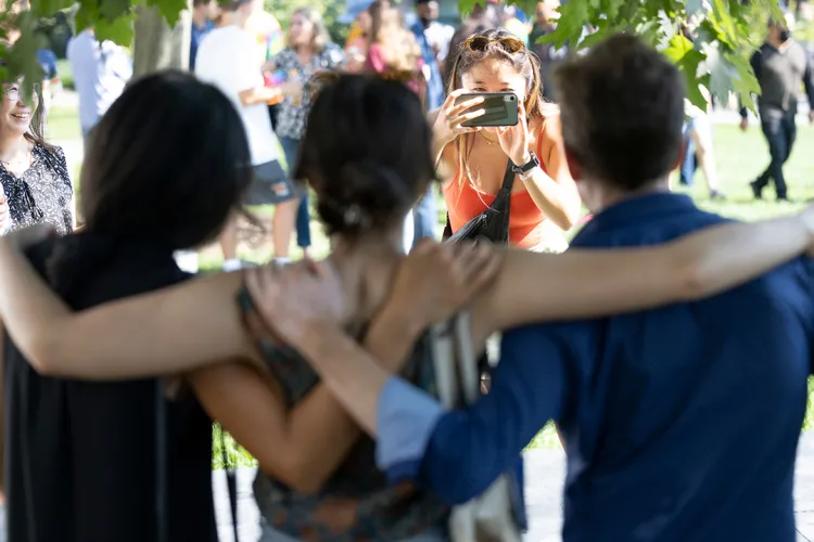 Students hug while wearing masks
