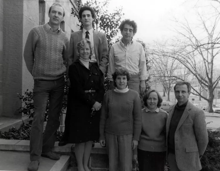 Black and white photo of psychology department posing for group photo on building steps