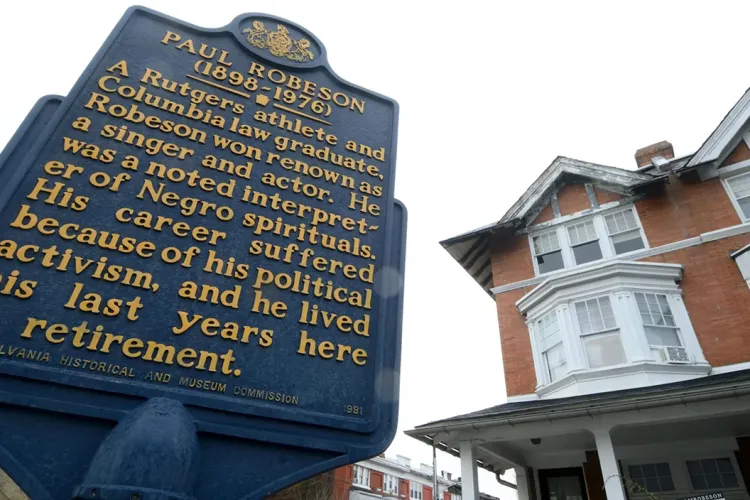 Paul Robseon House in background with blue and yellow historical marker in foreground