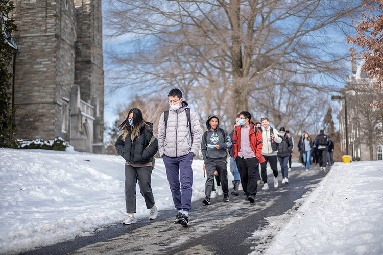 Students walk down hill in snow