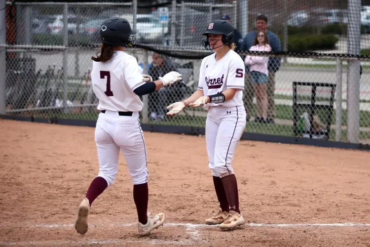 Two softball players exchange high fives