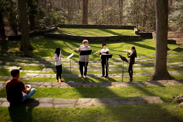 Students play instruments in outdoor amphitheater