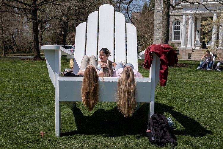 Students sit on Parrish Beach Big Chair