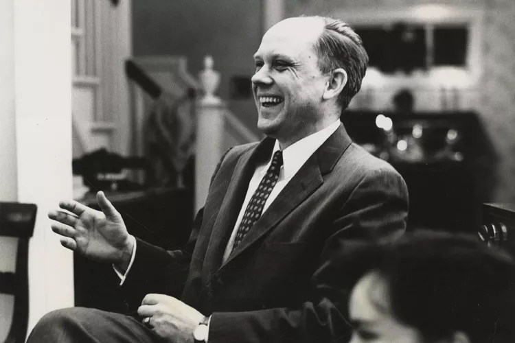 Man wearing suit sitting in parlor in black and white photo