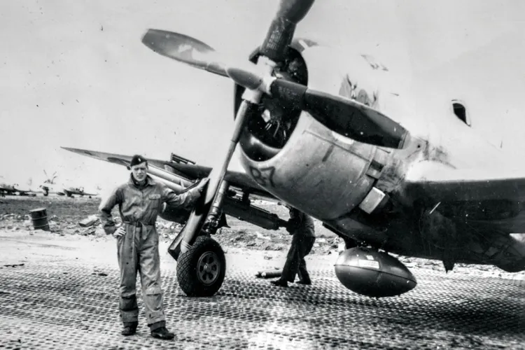 Person in Air Force stands in front of fighter plane on runway