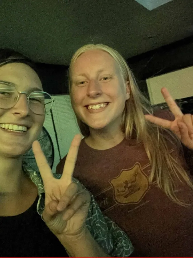 2 students making peace signs with their fingers