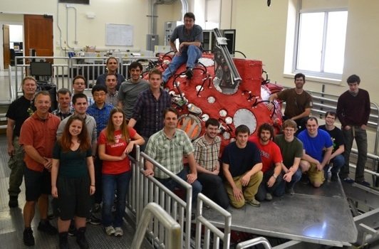 Team posing in front of equipment as part of Madison Plasma Dynamo Experiment (MPDX)