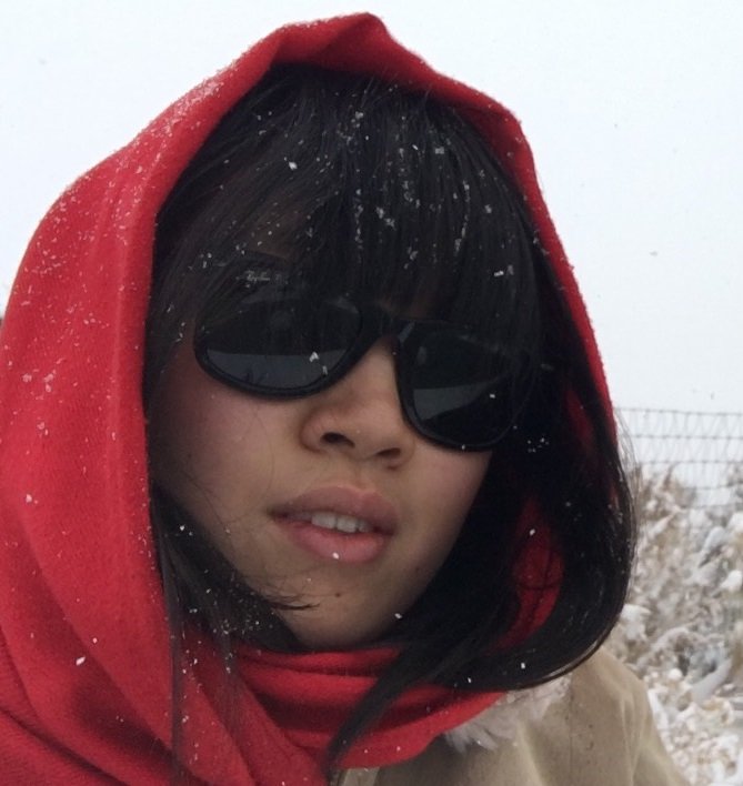 student wearing hoodie and sunglasses on a snowy day