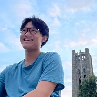 photo of student smiling next to Tarble Clothier hall