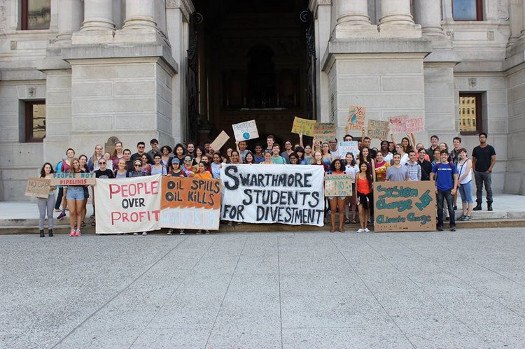 A group of Swarthmore students holding posters calling for divestment from fossil fuels