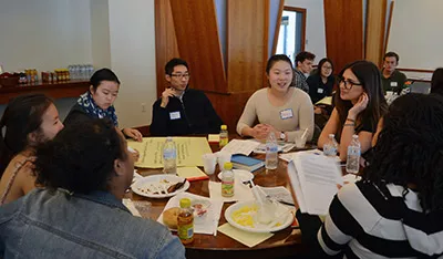 Student leaders talk to each other around a table