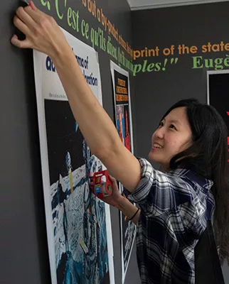 Student tapes poster to wall