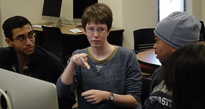 Students use sign language with each other while working at computers
