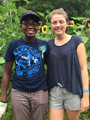 Two students stand in a garden on Swarthmore's campus