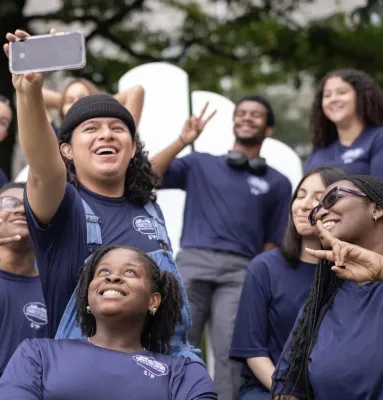 Swarthmore Summer Scholars gather for a group photo on a large Adirondack chair.
