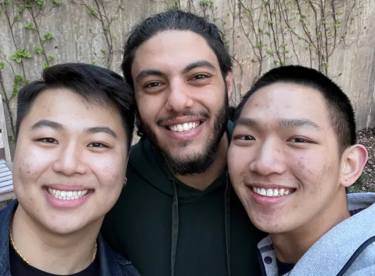 Three students pose for a selfie