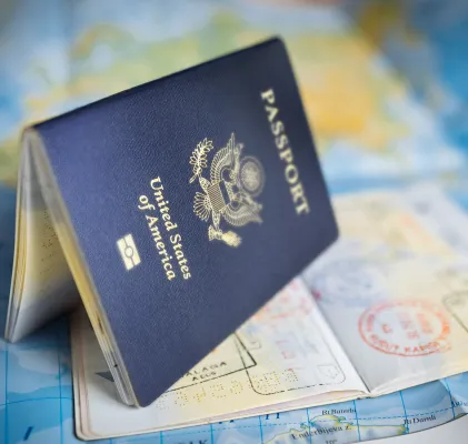 Passport book fanned open and sitting on top of a world map