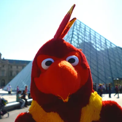 Stuffed phoenix figurine is held in front of the louvre in Paris