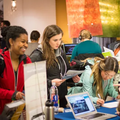 Students smiling around a table at at conference expo