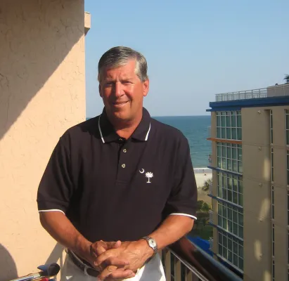 Man standing on balcony by the sea
