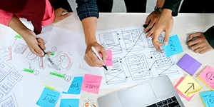 students around a table working on wireframing designs