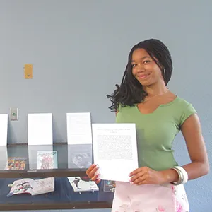 Zuri Eason standing beside a display of her award winning collection