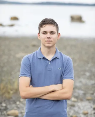 Joshua with crossed arms in front of water