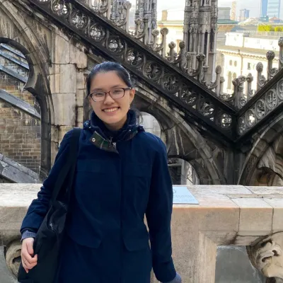 Female student stands facing camera on a bridge in Paris