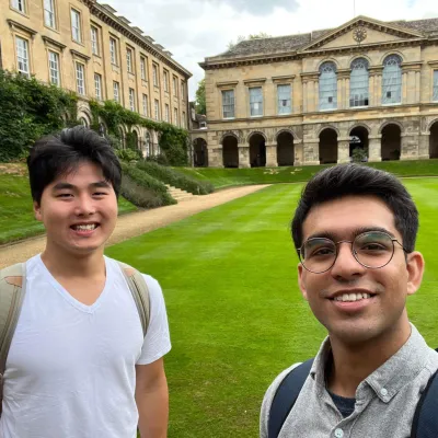 Two male students stand on a very green lawn in Oxford quad