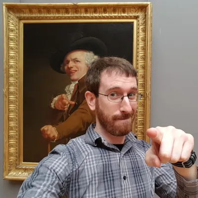 Kevin Webb making a silly pose in front of painting