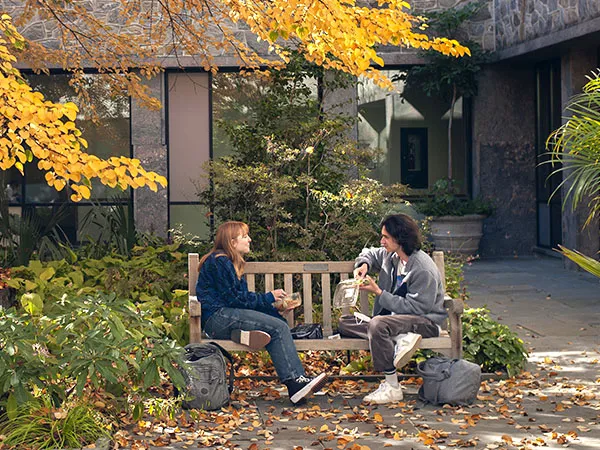 two students talking on a bench