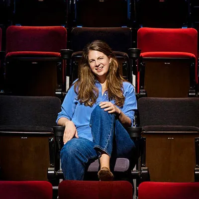 Nell Bang-Jensen sits in red theater chairs