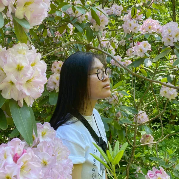 student with flowers behind them