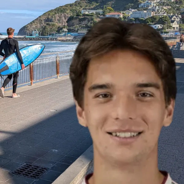 Male student stands on oceanside promenade in NZ