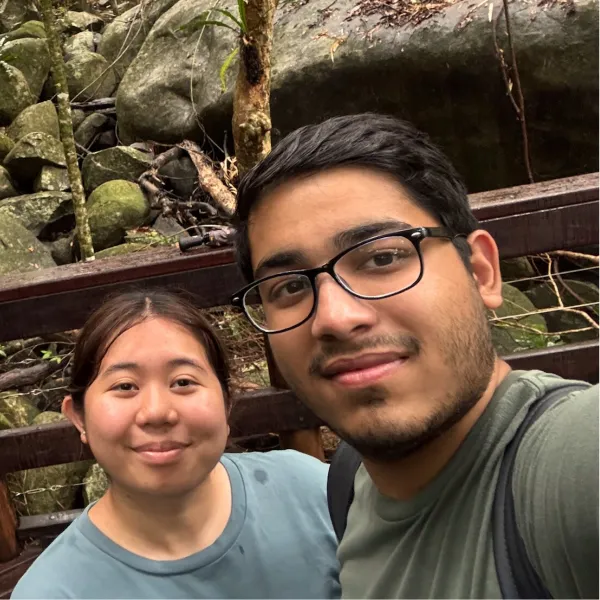 Male and female student stand in front of waterfall in Australia