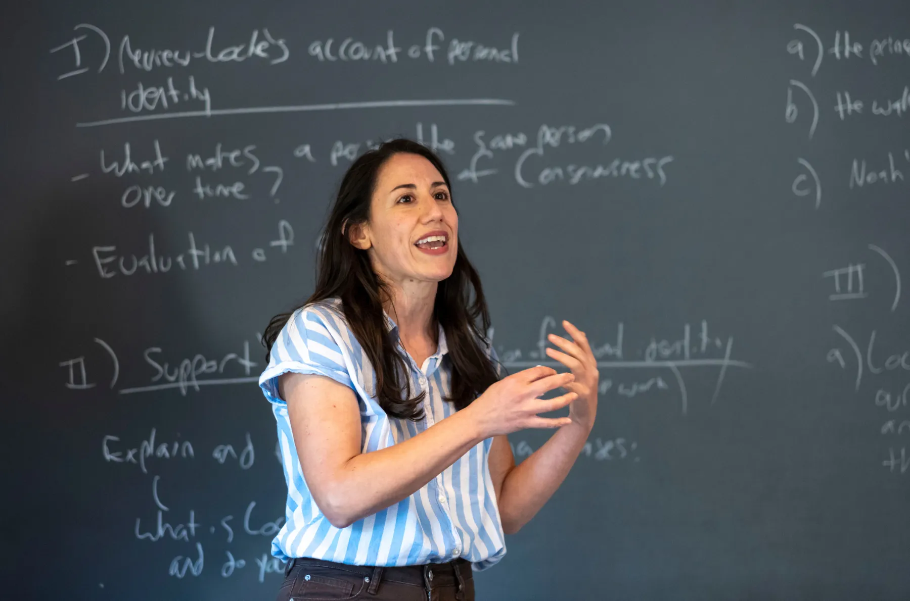 Philosophy professor in front of chalkboard lecturing to classroom