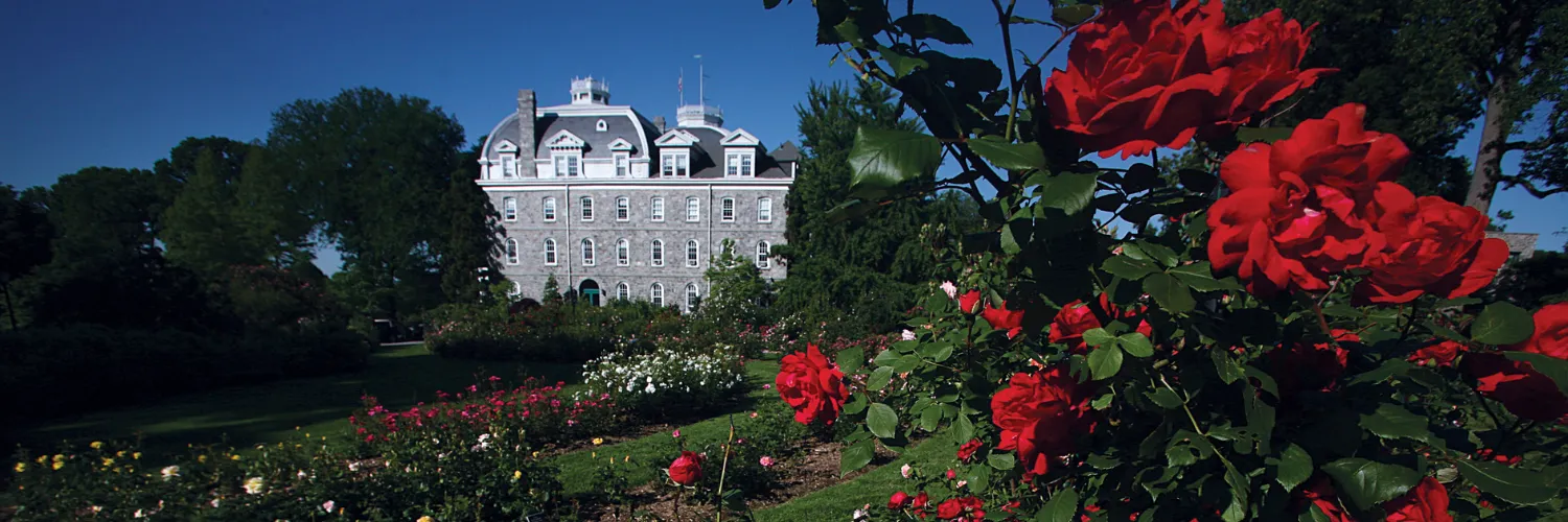 View of Parrish Hall through the Rose Garden with Red Roses