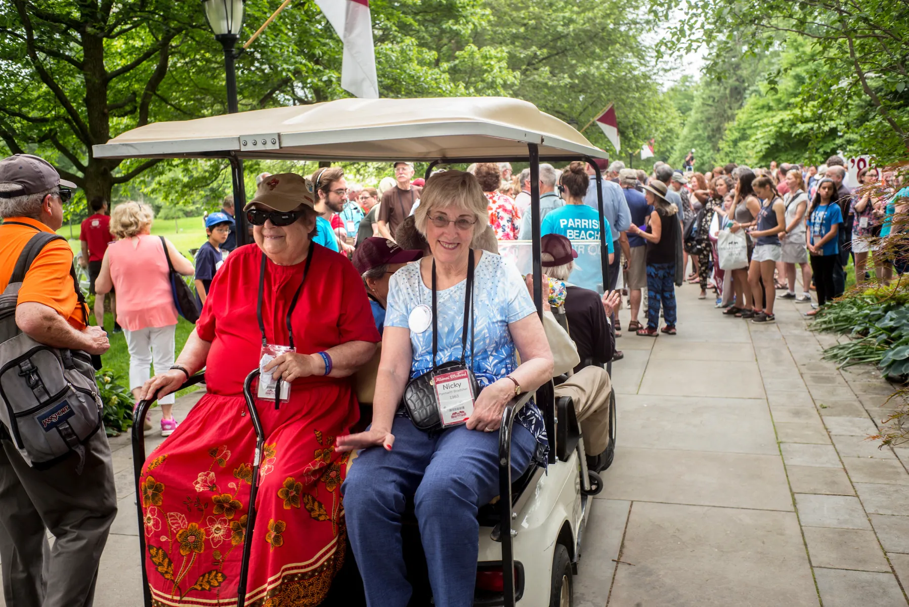 Alumni ride on a golf cart during the Parade of Classes