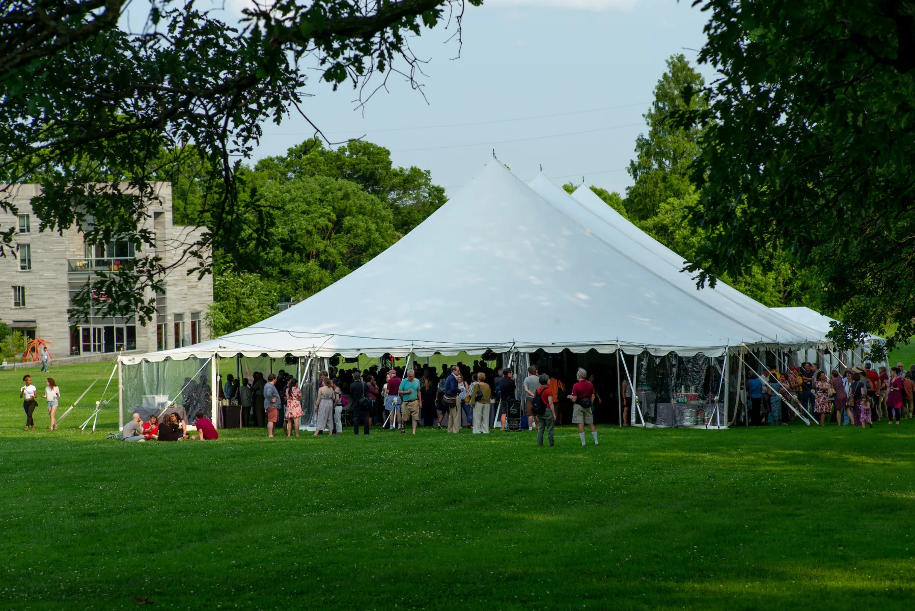 Alumni gather under a tent on Parrish Beach