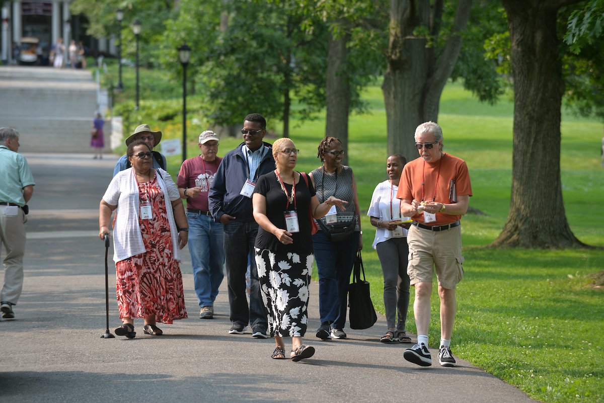 A group of alumni walk down the hill