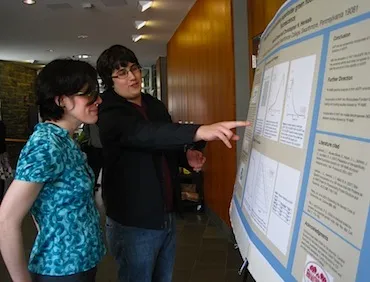 Sam Tanner '14 discusses his research poster with Professor Holliday.